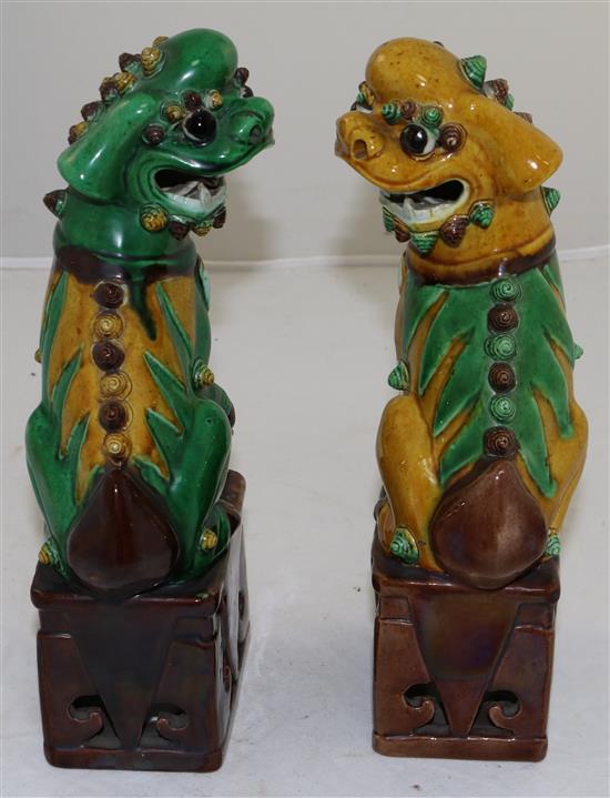 A pair of Chinese sancai glazed figures of Buddhist lions seated on plinths, 19th/20th century, 25cm